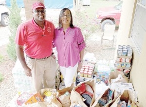 Photo by Donna Campbell/Johnnie and Stephanie Turner, The Doll’s House’s executive directors, stand amid bags and cases of groceries donated to the organization Tuesday by Gentiva Hospice.