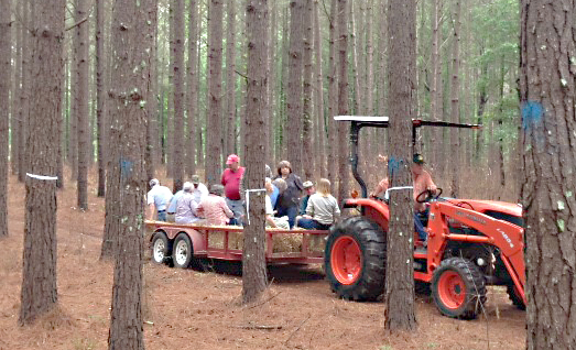 Photo submitted/Locals hitch a ride into the forest on a tractor for the 2015 Lincoln County Forestry Association seminars.