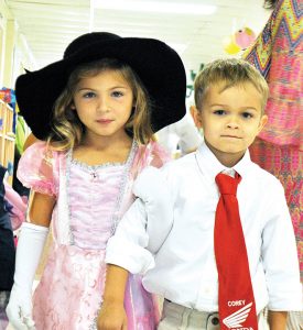 Alli Case and Preston Hickman link arms Friday as they and their fellow students prepare to attend the elegant elephant party.