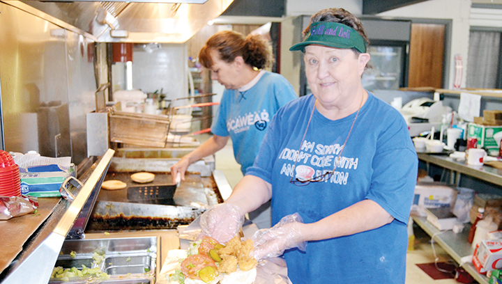 Photo by Donna Campbell/Lynda Williams prepares a shrimp po’ boy at Mardi Gras Grill while her daughter, Deborah Blackshear, flips a burger.