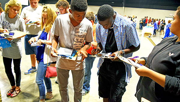 Photos by Julia Miller / Kwaman McClendon, left, and Ladarius May help each other balance their checkbooks during the insurance station at the annual Reality World. Students from surrounding schools were given an income based on their GPA and had to make budgeting decisions, such as whether to rent or buy and which cell phone plan. The event was sponsored by Junior Auxiliary and supported by community business leaders.