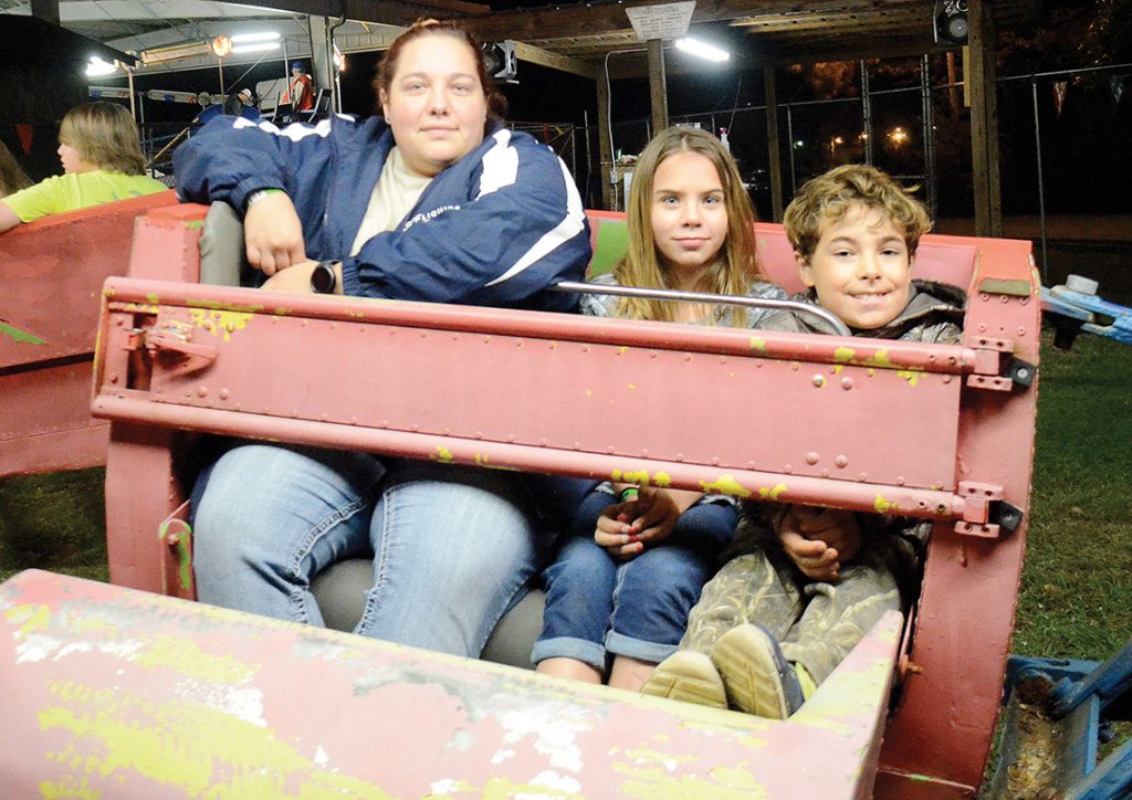 Photo by Aaron Paden/Shirley Dardar (left), Eliza Walley and Joman Lewis wait excitedly for The Scrambler to start at the Log A Load fundraiser Saturday at the Exchange Club Park. The fundraiser raised over $30,000 in one day for the Blair E. Batson Children’s Hospital.