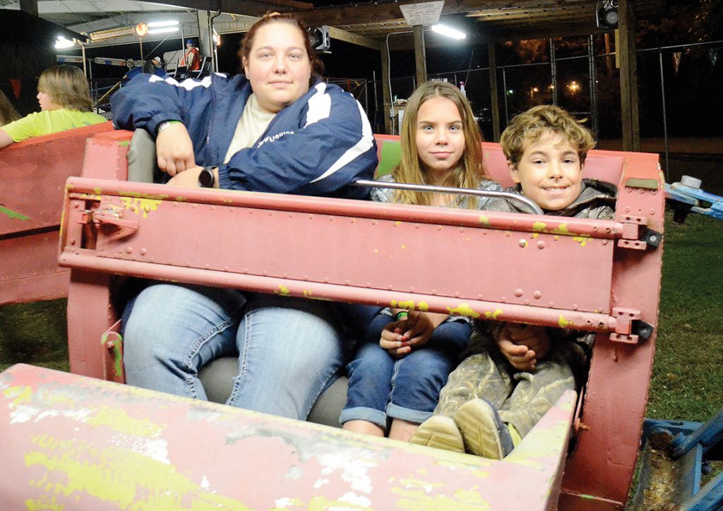 Photo by Aaron Paden/Shirley Dardar (left), Eliza Walley and Joman Lewis wait excitedly for The Scrambler to start at the Log A Load fundraiser Saturday at the Exchange Club Park. The fundraiser raised over $30,000 in one day for the Blair E. Batson Children’s Hospital. 