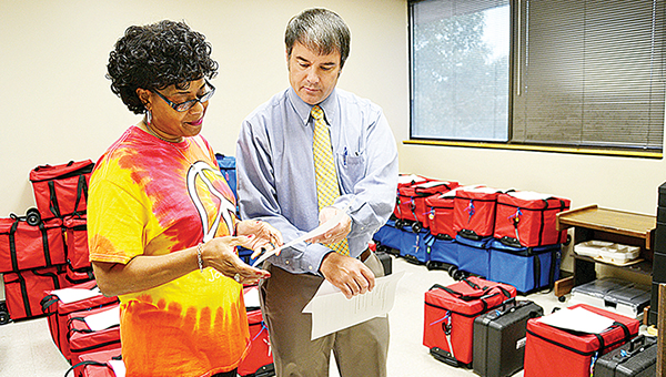 Photo by Donna Campbell/Carolyn Kees, poll manager for the Johnson’s Grove precinct, goes over some last minute instructions with Lincoln County Circuit Clerk Dustin Bairfield Monday. Polls are open until 7 p.m. today.