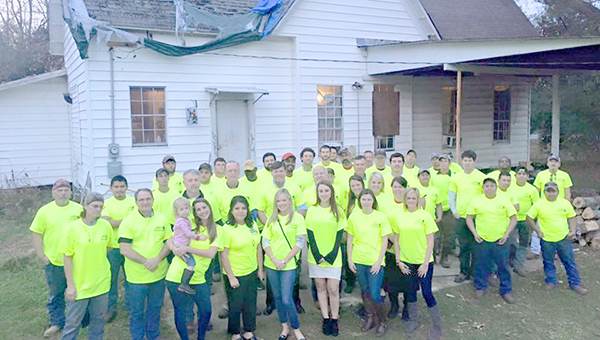 Photo submitted/Reed’s Metals employees gathered at Sara Armstrong’s home last year to install a free metal roof. Armstrong was selected as the Lincoln County recipient of the corporation’s “Covering the Community” project. The company is currently accepting nominations for a family in need of a roof this holiday season at www.reedsmetals.com.