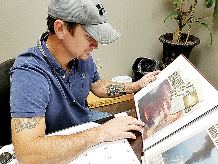 Photo by Donna Campbell/Ken Roberts looks over a scrapbook of news articles he’s collected about the Deepwater Horizon explosion. Roberts, of Loyd Star, was one of 126 workers on the oil rig that exploded in 2010.