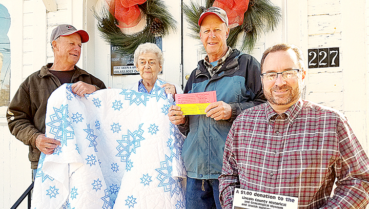 Photo by Donna Campbell/Carroll Montgomery (left), Sue Dorman, Harrell Montgomery and Kevin Laird show off the handmade quilt that will be given away Dec. 4 at the Lincoln County Historical and Genealogical Society’s open house. Tickets for the raffle are $1 each and will be sold up until the drawing during the event.