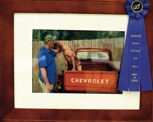 Gwin Robertson’s “Man and Best Friend” won Best in Show at BRAG’s annual art competition. Robertson, who has been painting since 1988, said she was inspired by the image of her neighbor petting his dog.