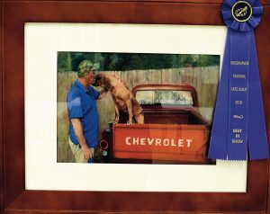 Gwin Robertson’s “Man and Best Friend” won Best in Show at BRAG’s annual art competition. Robertson, who has been painting since 1988, said she was inspired by the image of her neighbor petting his dog.