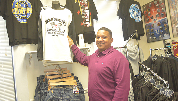 Photo by Orionna BrumfieldBasketball coach-turned-businessman Robert Hines hangs up merchandise in SBS Trends, a clothing store he and his family own in Brookhaven.