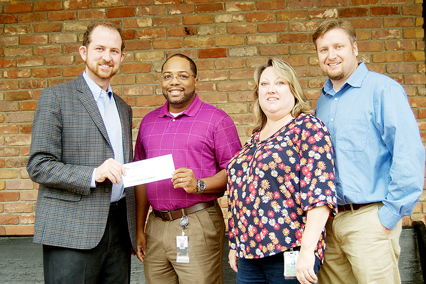 Photo by Donna Campbell/Shaheed Hickman, vice president of distribution at McLane Southern, presents a check for almost $10,000 to Jason Snider with the United Way of Lincoln County (far left) along with Sandy Dussetschleger, expediter, and Jeff Brumfield, controller.