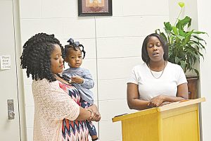 Photo by Donna Campbell/Alicia Leggett, holding her daughter Kinsley Dickey, sings with her sister, Ashley Leggett, at the Brookhaven’s First Achievers Black History Month reception Saturday at the Lincoln County Public Library. The exhibit, organized by Maxine Allen and Jennifer Allen-Stenson, spotlights dozens of black Lincoln Countians. It will remain on display throughout the month.